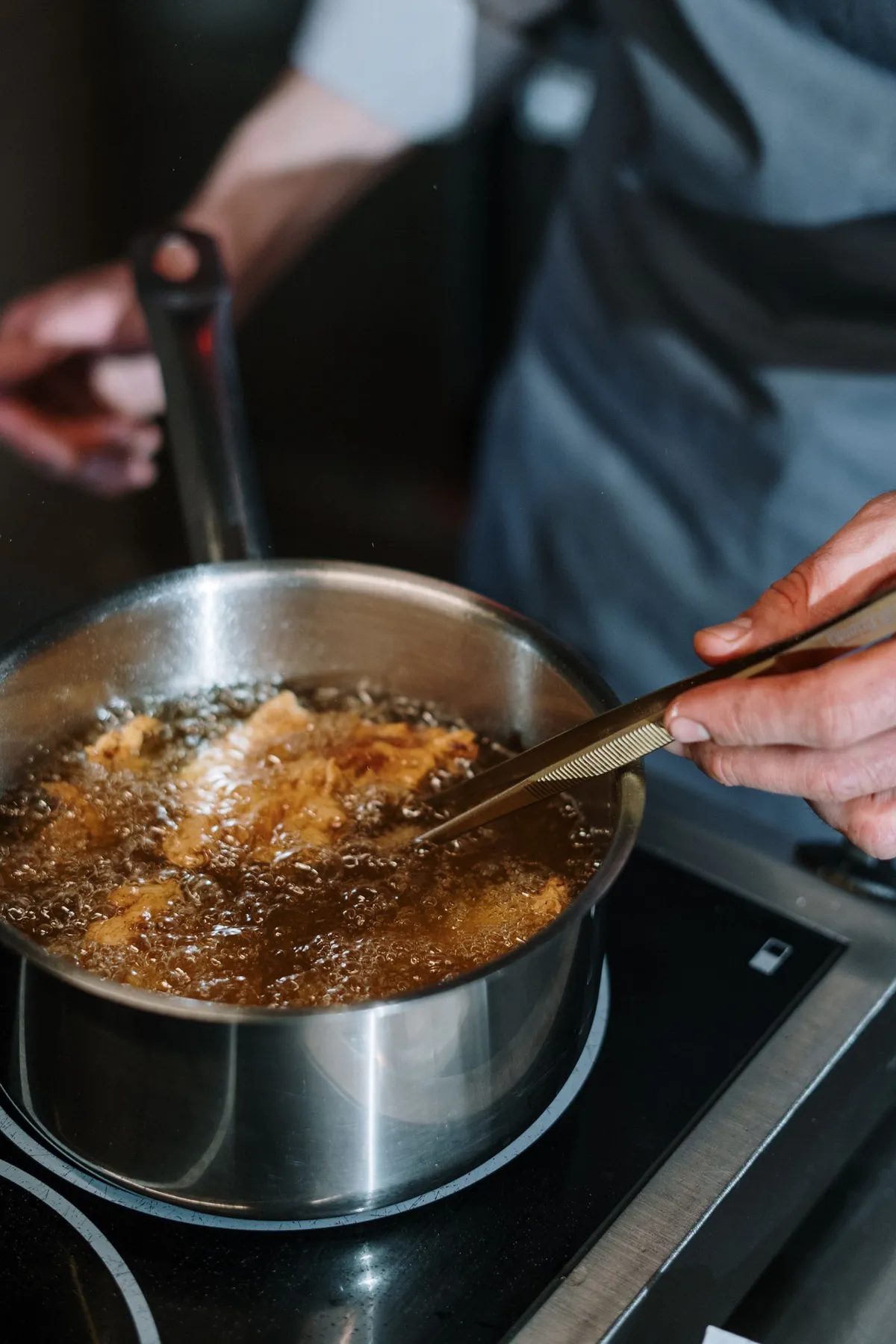 Detalle de cocinado en una sartén de acero inoxidable al fuego