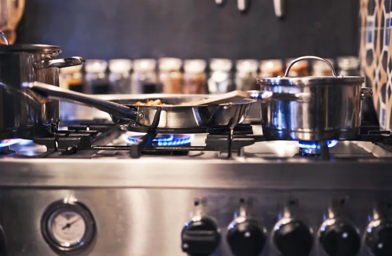 Ollas de acero inoxidable sobre el fuego de una cocina de gas